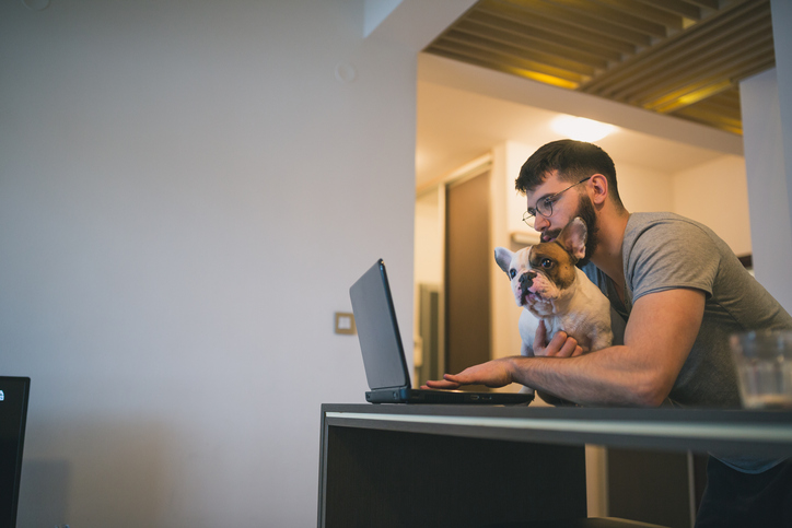 Man researching om the internet with his dog on lap