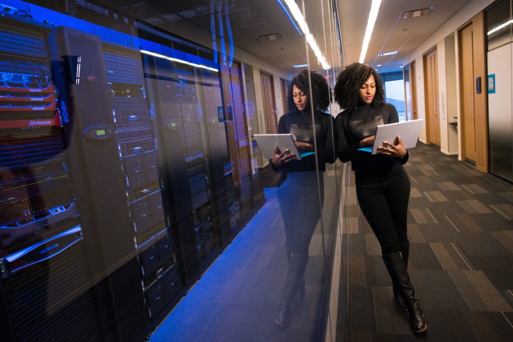 Woman leaning on a glass wall between her and domain servers.