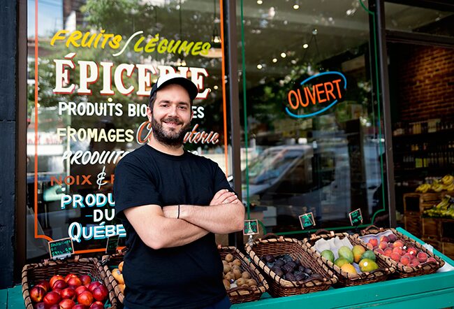 Shop owner standing in front of his store that sells produce local to Quebec